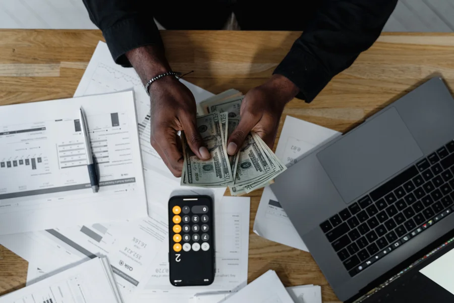 Person reviewing budget and spending plan at a desk with notebook and laptop