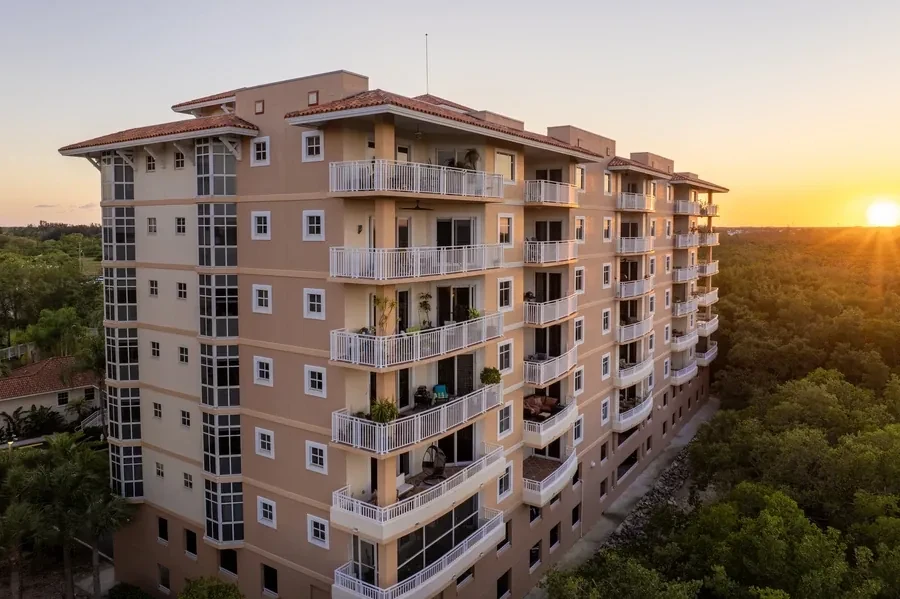 Tall Florida condo building with tiered balconies lit by sunset, the kind of project that needs FHA approval before a buyer can finance a unit