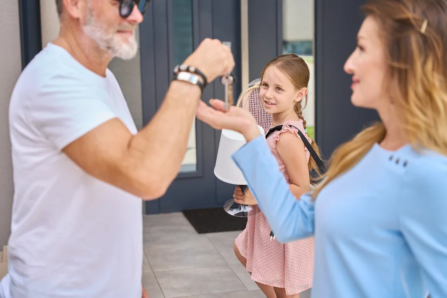 Family exchanging keys after assuming FHA mortgage from loved one
