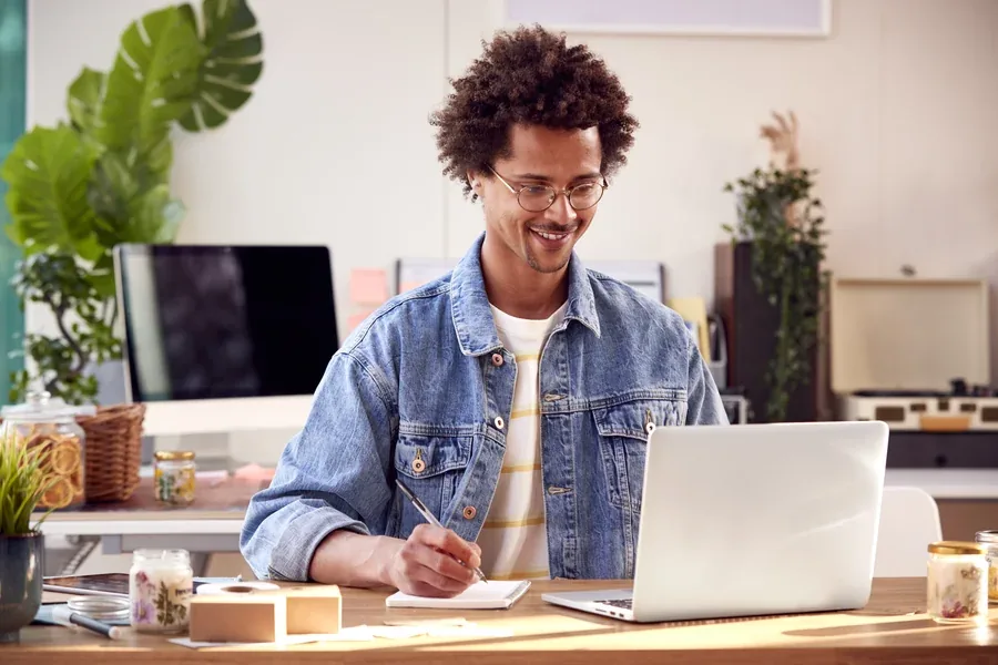 Self-employed man working on a laptop at a candlelit desk, the kind of gig income lenders have to document
