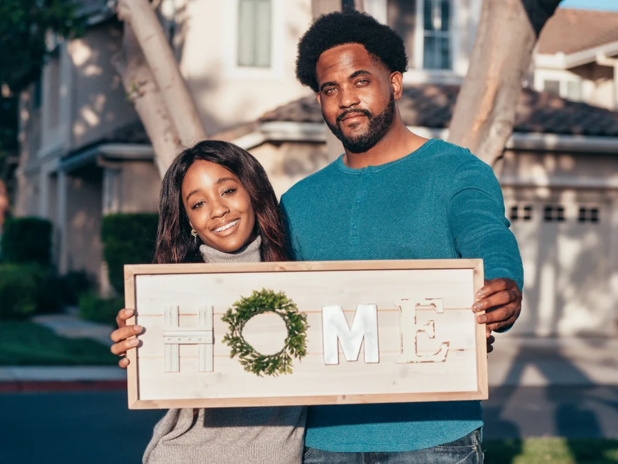 Family celebrating homeownership keys in front of their new home