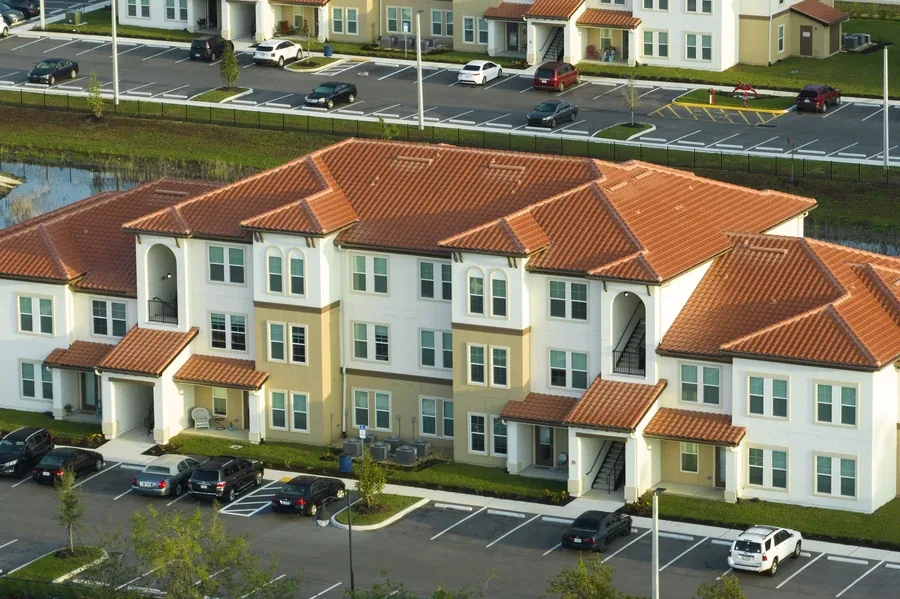 Aerial view of a small multi-family apartment building with parking in Florida, the type of property used for house hacking