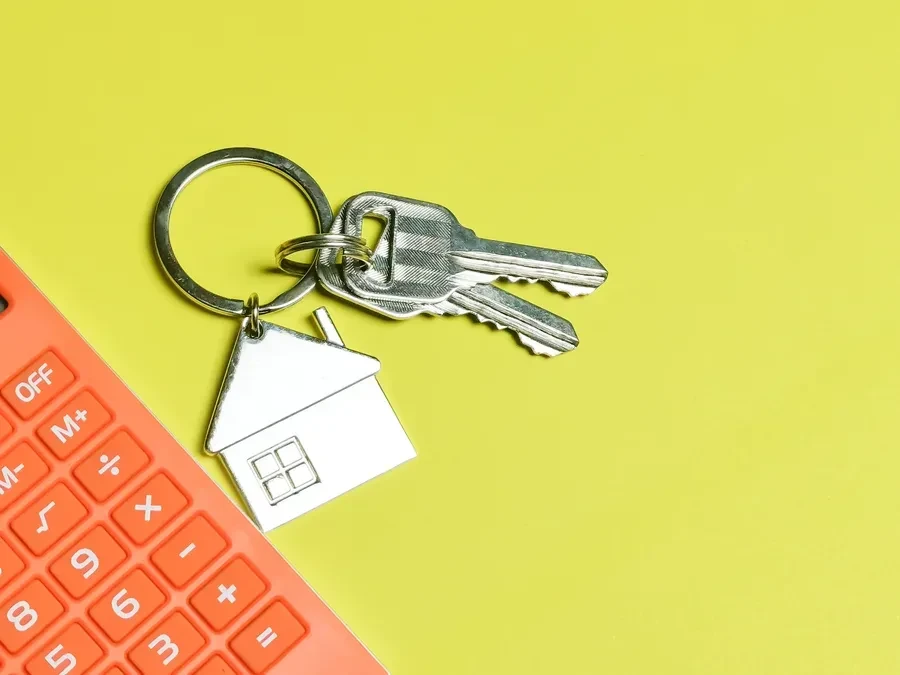 House keys and a calculator on a desk, a picture of running the numbers on a Florida mortgage refinance