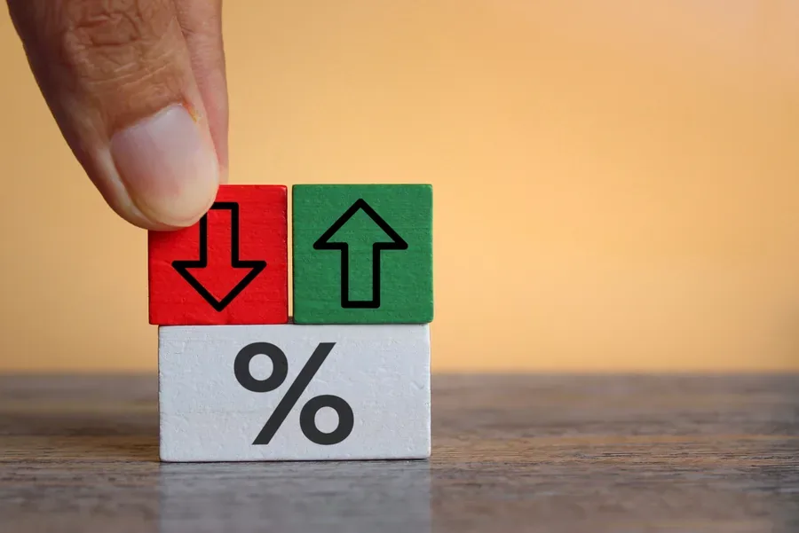 Wooden blocks with percent signs and arrows showing mortgage rate movement before Florida's fall buying season