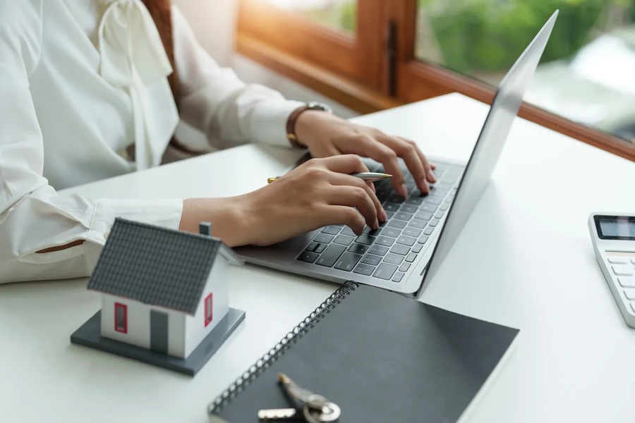 Calculator and laptop on a desk, working through a mortgage amortization schedule