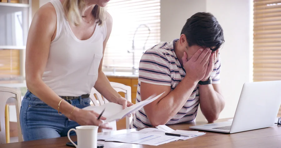 Couple discussing mortgage red flags and loan approval stress on laptop