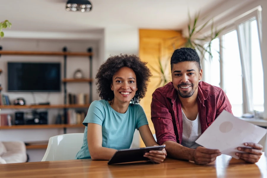 Couple reviewing mortgage pre-approval letter with loan officer before making an offer
