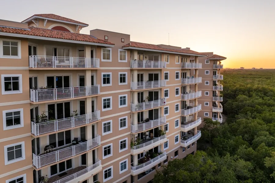 Mediterranean-style Florida condo building with balconies at sunset, the kind buyers finance as a second home or rental