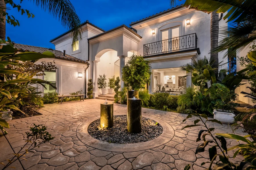 Mediterranean style Florida home with a lit fountain and palms at twilight, the kind of property investors finance as a short-term rental